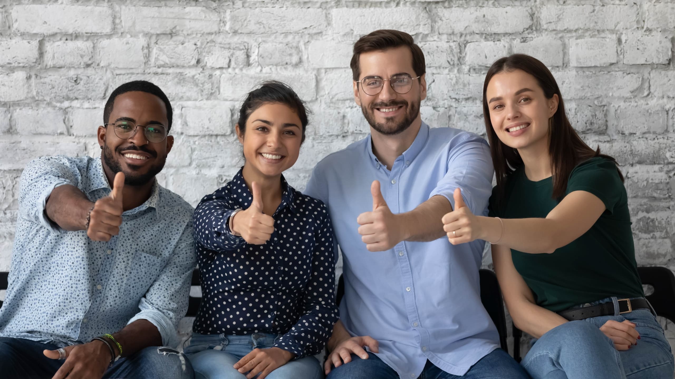 Diverse group of people giving a thumbs up sign
